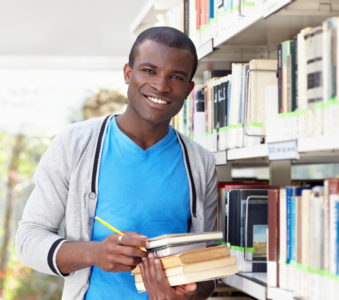 young african man smiling in library